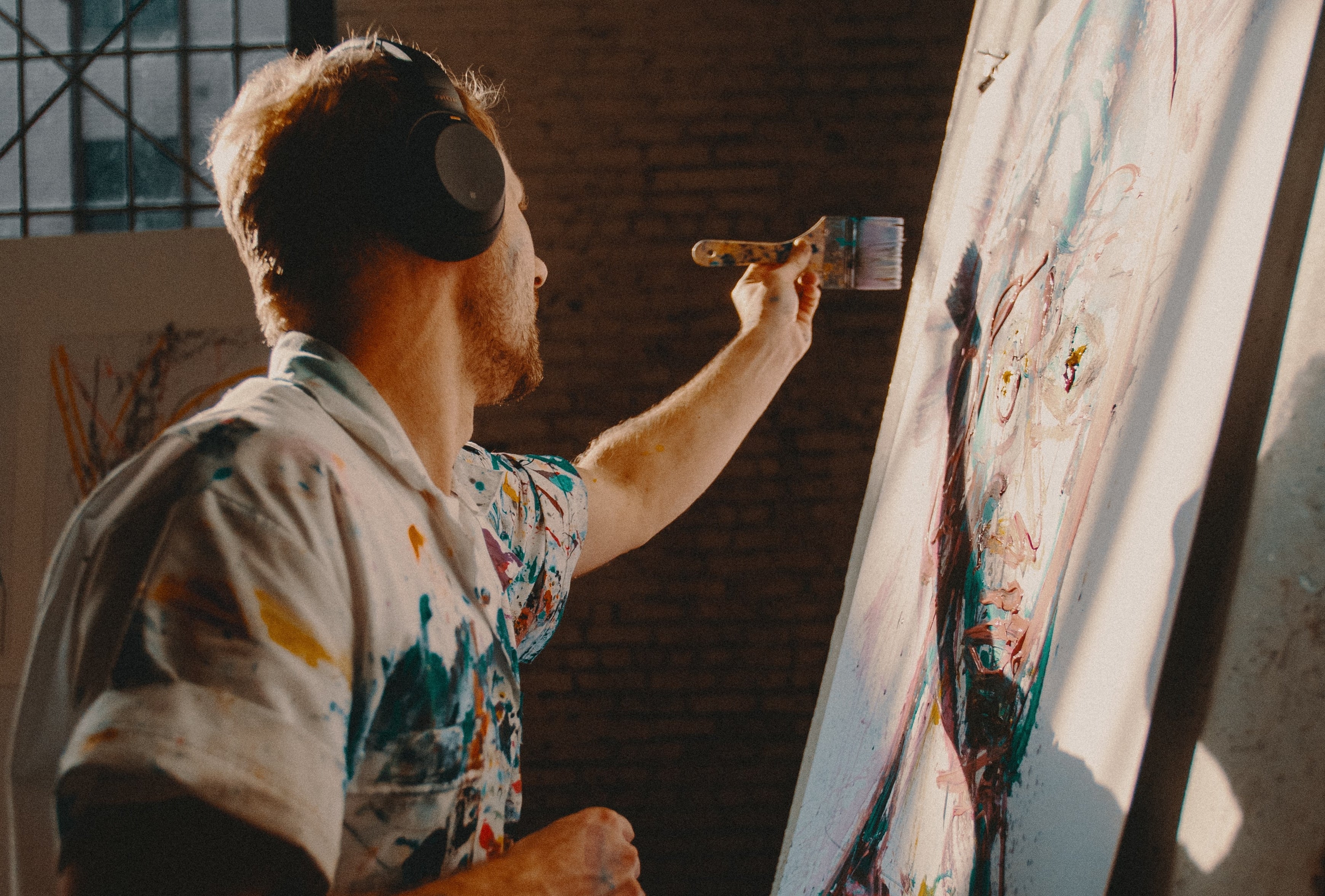 A male artist painting on a large canvas