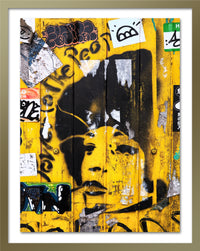 A poster that depicts the portrait of a woman painted with a stencil over a yellow wall